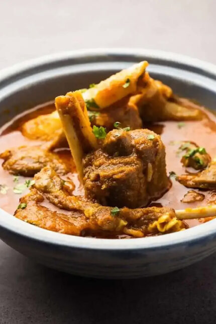 Tender cuts of bone-in mutton curry showcasing authentic regional Bengali spices.