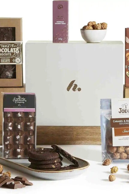 A luxury chocolate hamper displaying dark biscuits, popcorn, and a treat box.