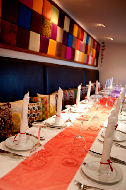 Elegant long party table setup with an orange runner for group dining at Zari Crawley.