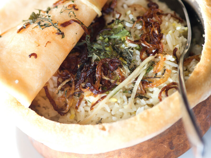 Authentic Indian pot biryani topped with fried onions at a restaurant near Gatwick.