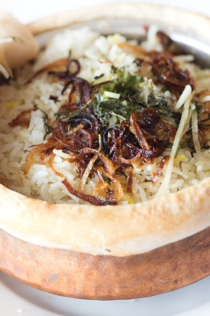 Authentic pot biryani topped with crispy fried onions and fresh mint leaves for a feast.