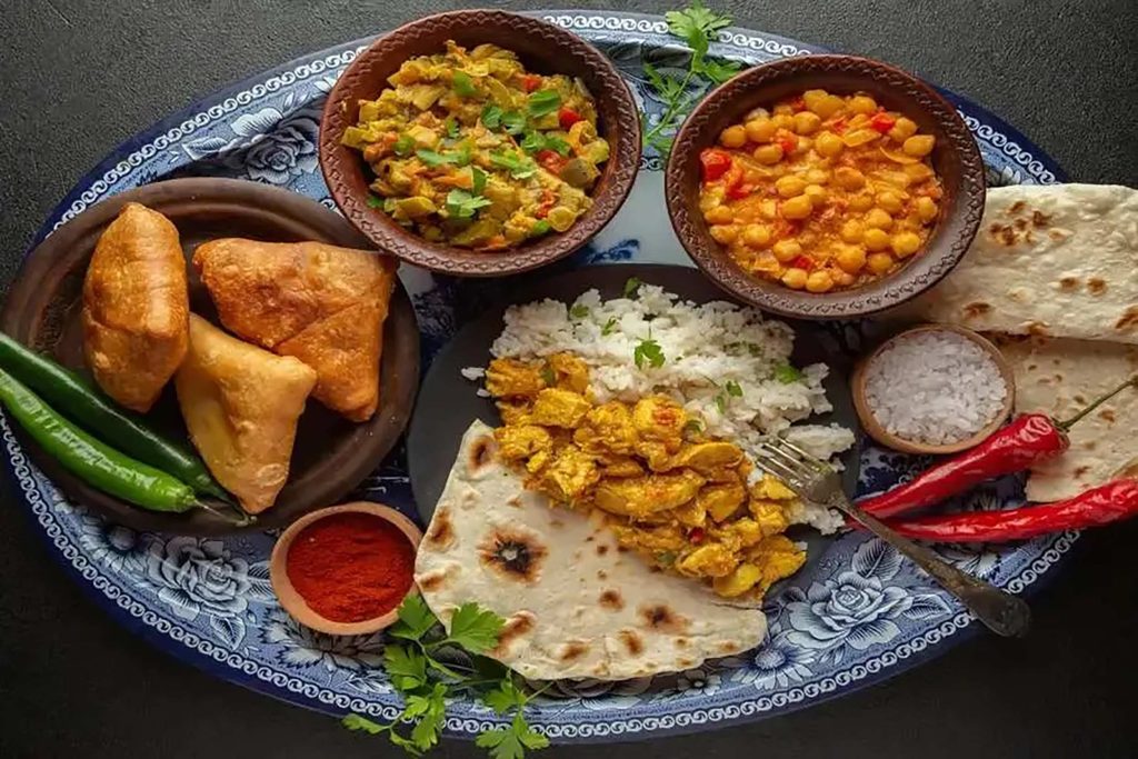 A balanced Indian meal platter with rice, flatbread, chicken, and healthy chickpea curry.