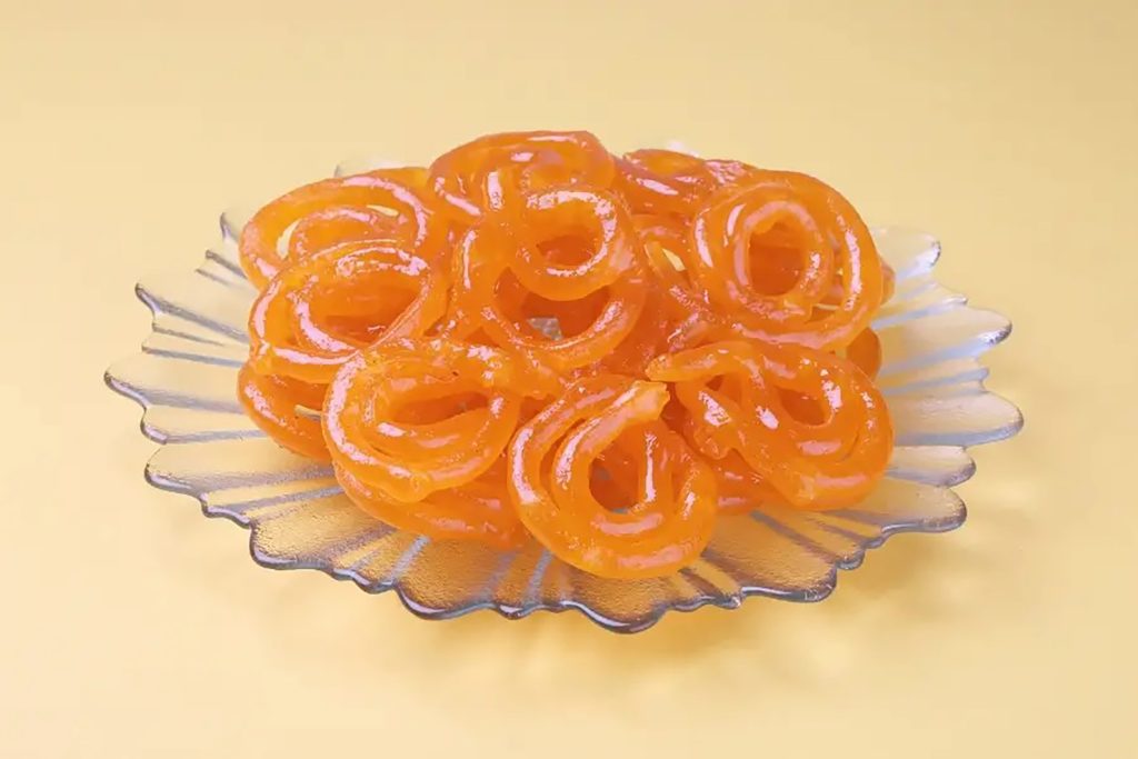 Crispy golden deep-fried Jalebi spirals in sugar syrup at Zari Restaurant Crawley.