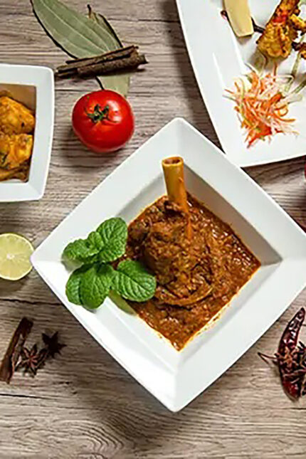 A rich vegan Indian curry surrounded by fresh spices, served near Brighton.