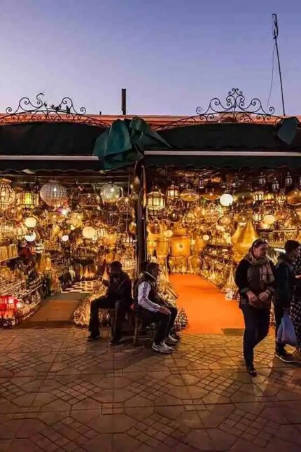 A traditional market stall filled with glowing Moroccan glass and metal lanterns.