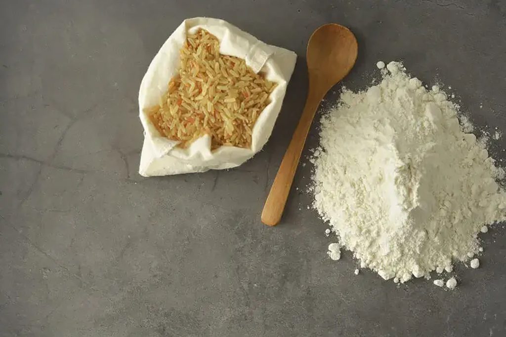 Raw brown rice in a sack with a wooden spoon and flour, highlighting healthy grains.