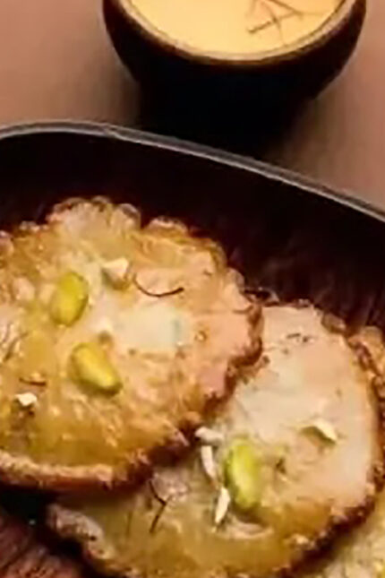 Fried sweet Mawa Kachori dipped in sugar syrup and topped with crushed green pistachios.