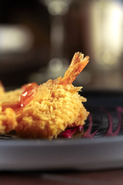 Golden crispy-fried Bengali prawn appetizer served on a premium dinner plate.