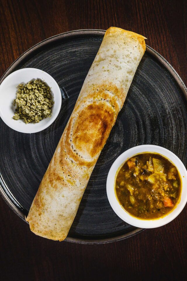 Crispy rolled Indian dosa served with flavorful side dipping curries at Zari Crawley.