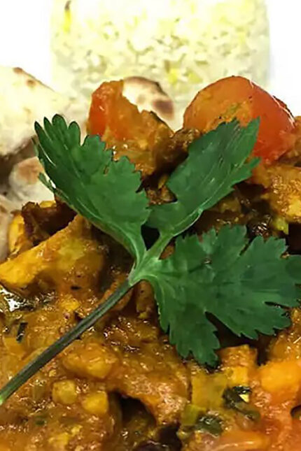 Rich and aromatic Turkey Bhoona curry garnished with fresh coriander at Zari Crawley.
