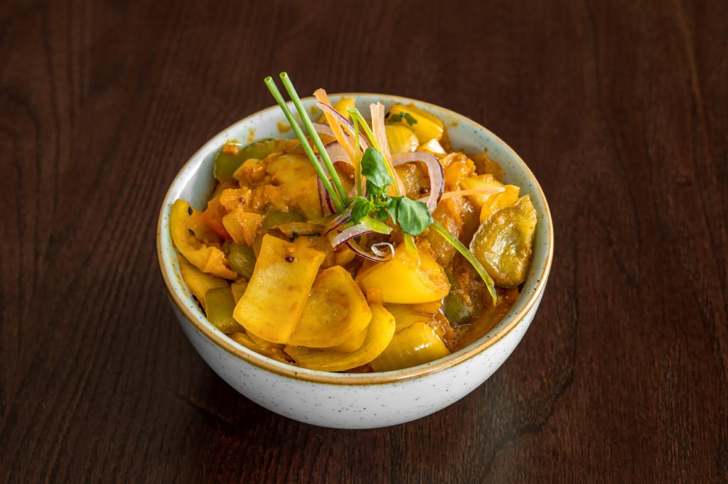 A vibrant bowl of spiced yellow vegetable curry rich in vitamins at Zari Crawley.