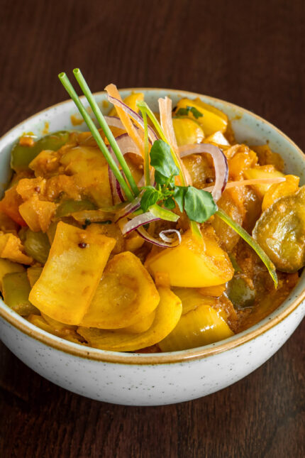 A vibrant bowl of spiced yellow vegetable curry rich in vitamins at Zari Crawley.