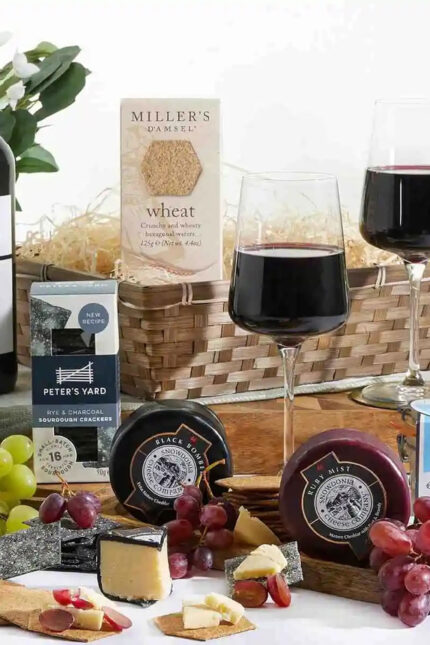 A gourmet corporate gift basket filled with premium cheeses, crackers, and red wine.