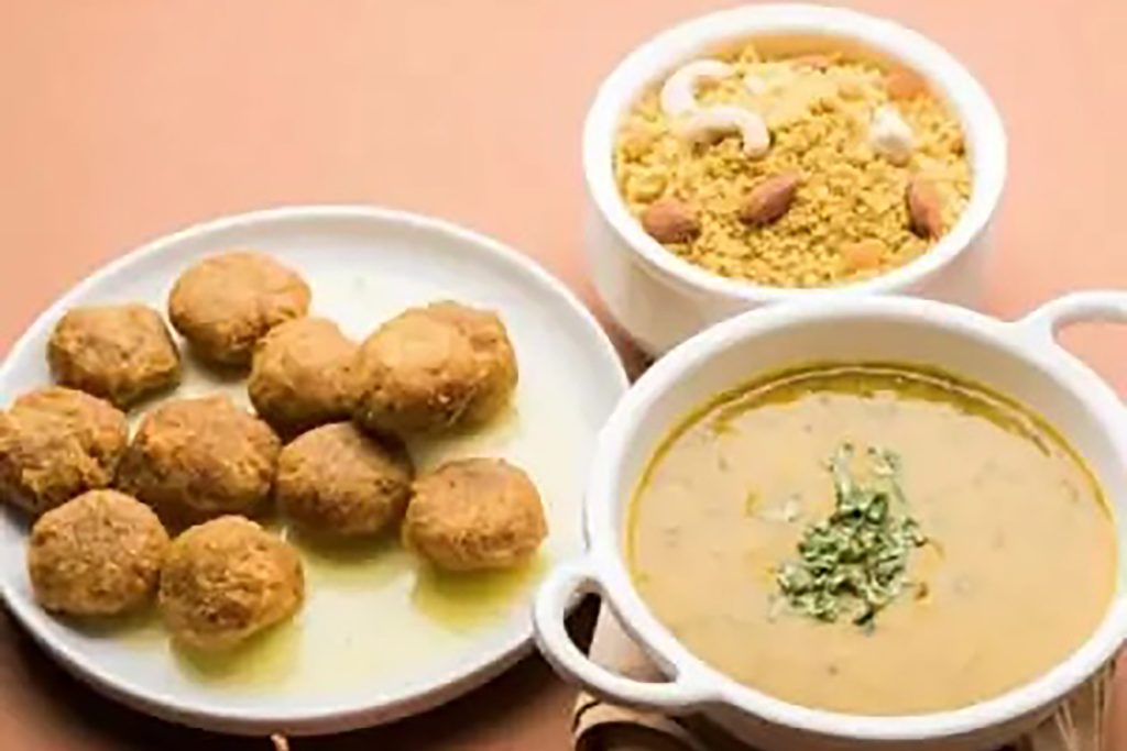 Traditional Rajasthani Dal Baati Churma served with hard wheat rolls, lentils, and rich ghee.