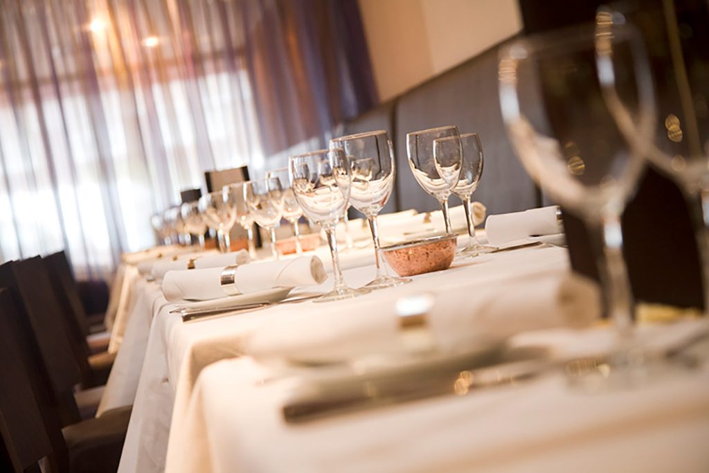 Close-up of an elegant restaurant table setting with polished wine glasses and linen.