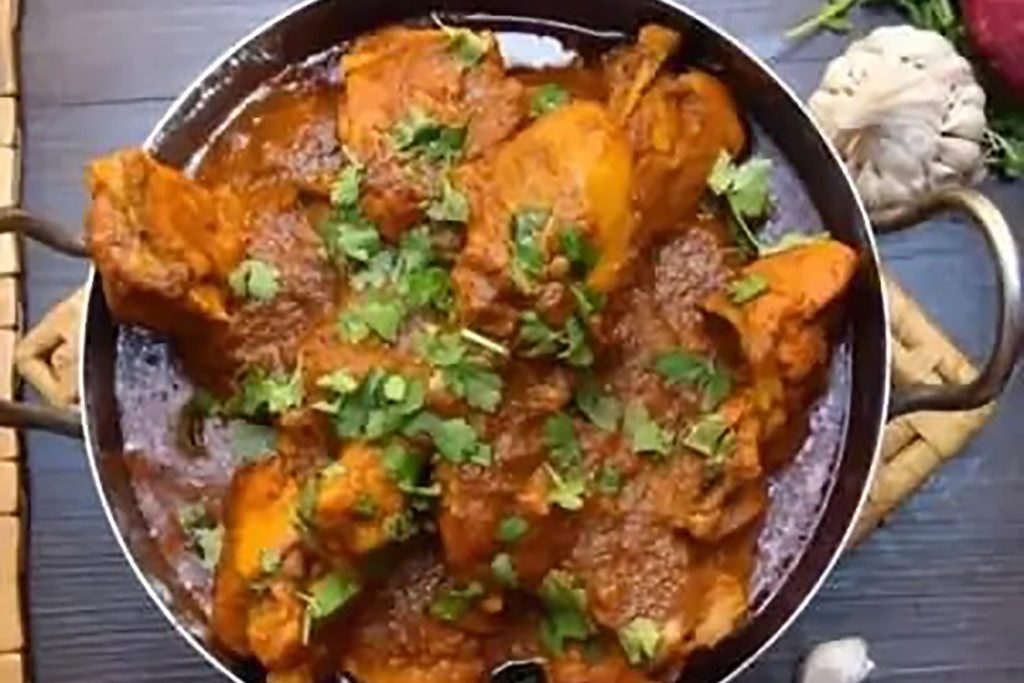 Spicy Rajasthani Laal Maas red mutton curry garnished with Kashmiri chillies at Zari in Crawley.