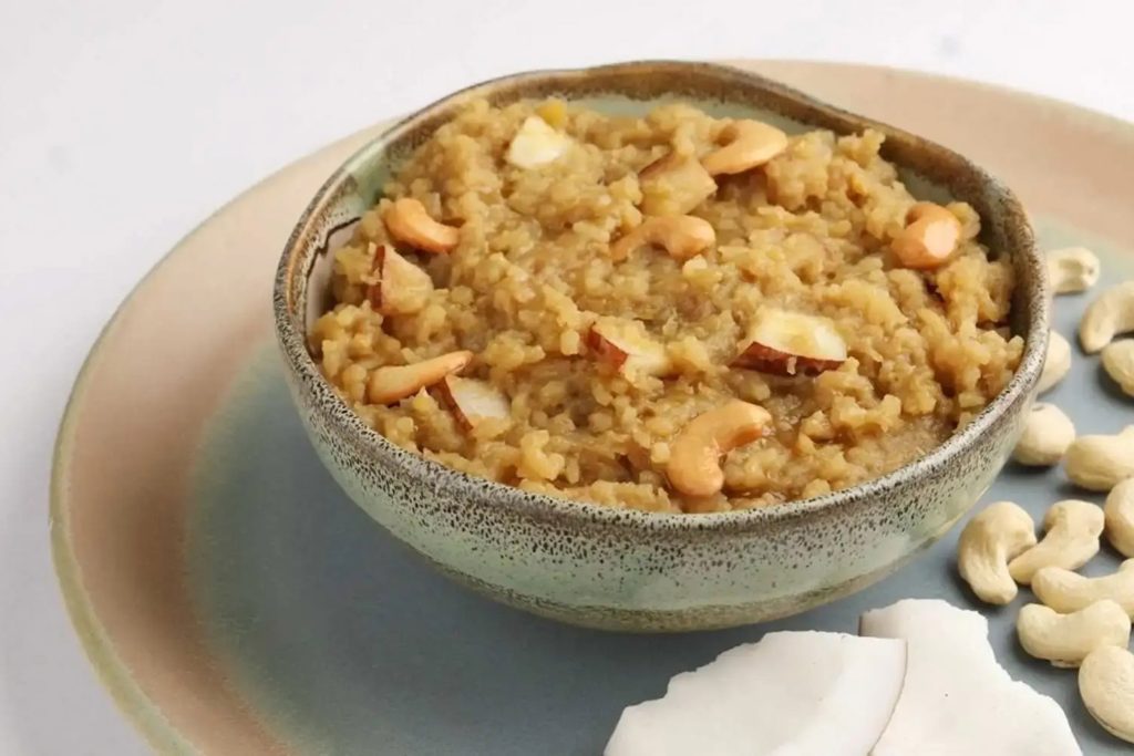 A bowl of traditional South Indian sweet pongal garnished with roasted cashew nuts.